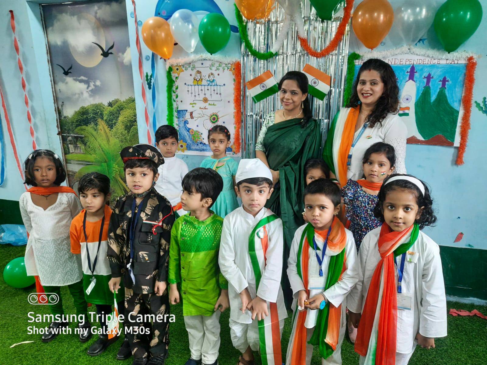 A teacher standing with children, smiling and having a good time together at Preschool in Hinjawadi.