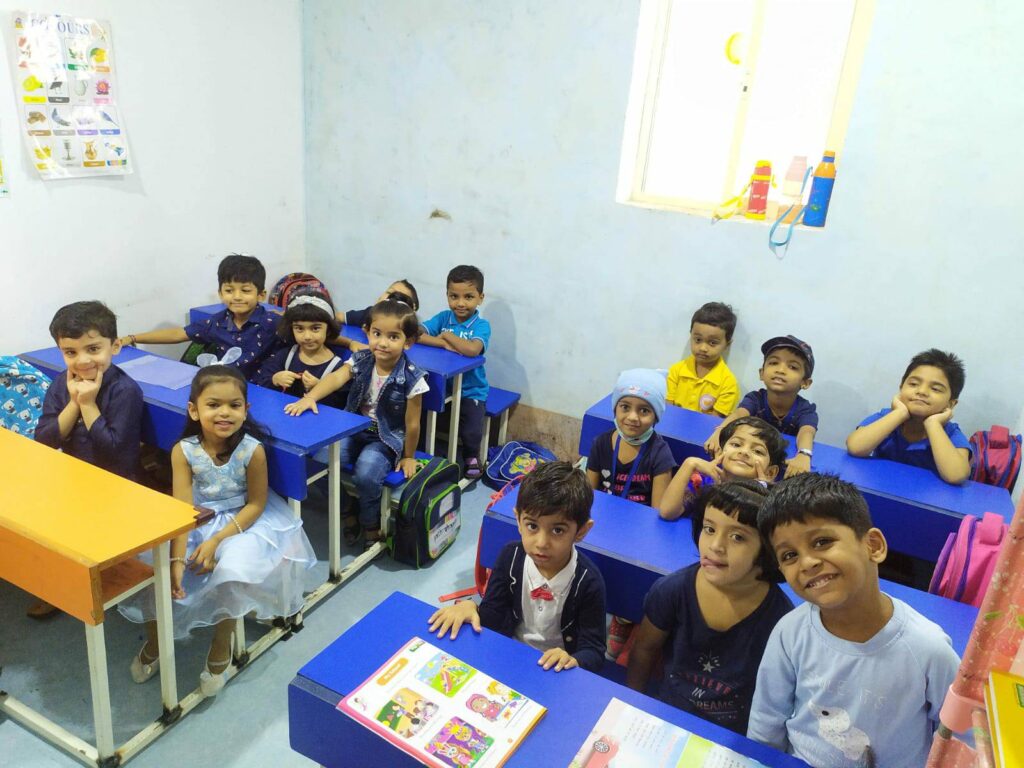 A student from Dr. Kamna's Gurukool Preschool sitting attentively in a classroom setting, engaged in a learning activity.