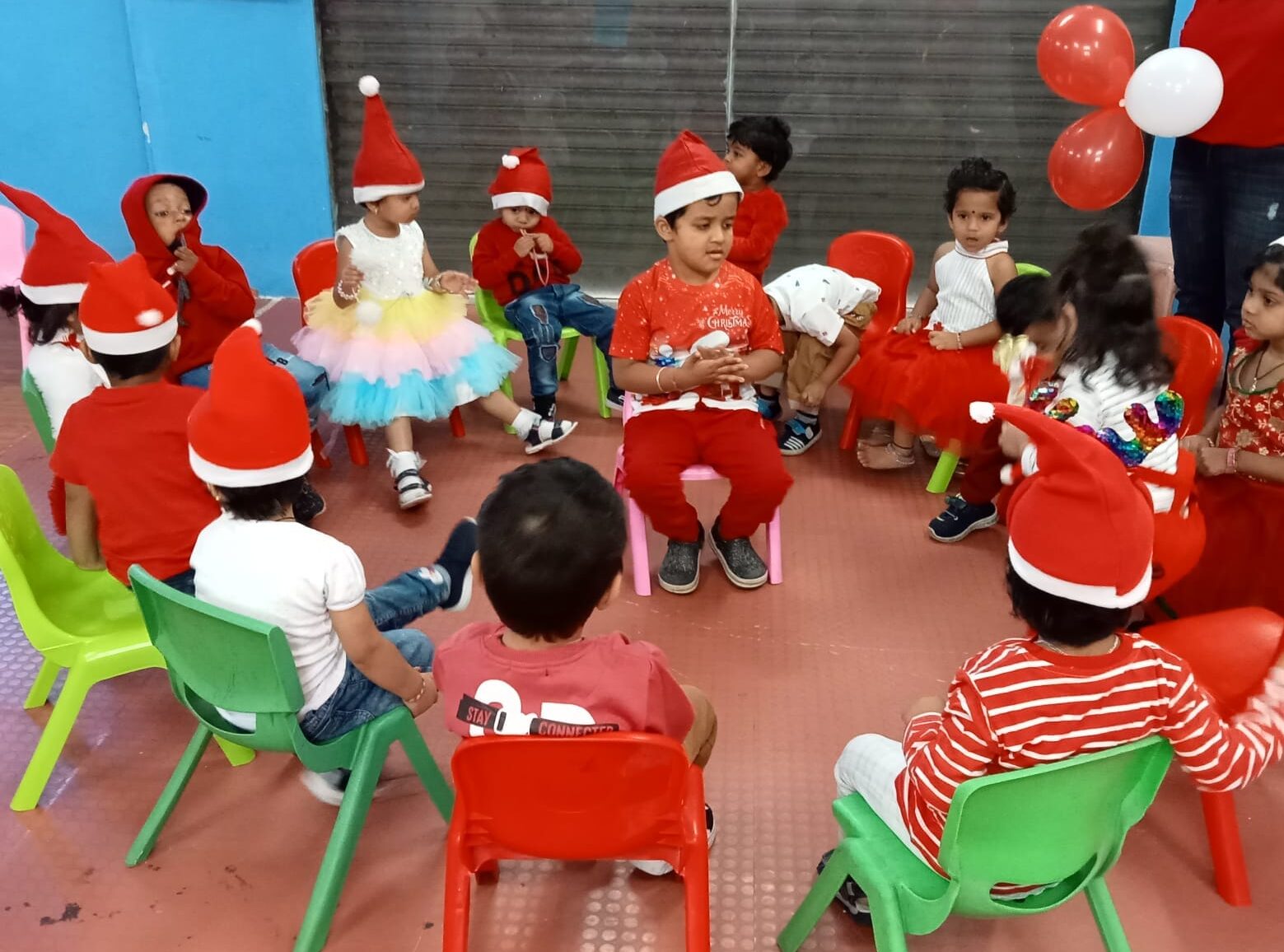 Preschool children celebrating Christmas with decorations, gifts, and festive attire.