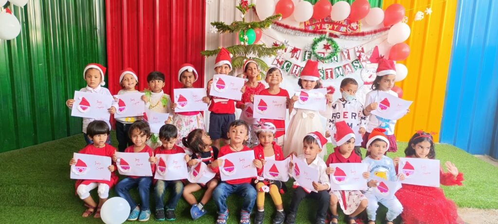 Preschool children celebrating Christmas with decorations, gifts, and festive attire.