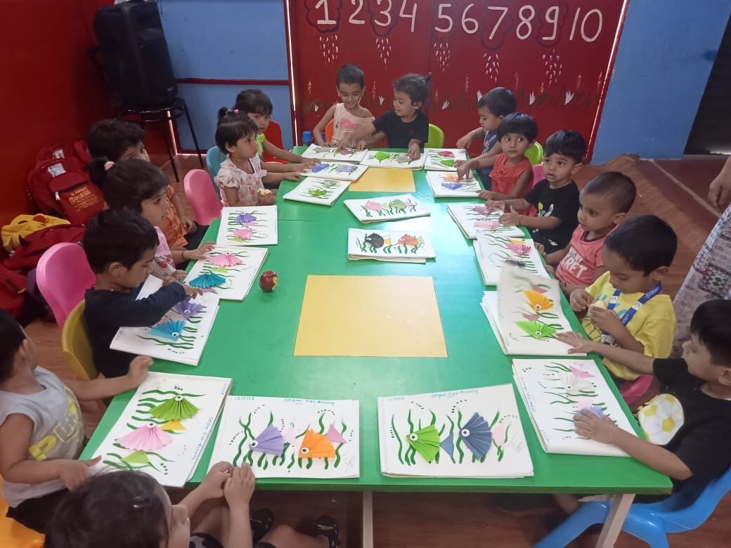 A group of children engaged in various educational activities, such as reading, writing, and math, with a teacher guiding them in Preschool.