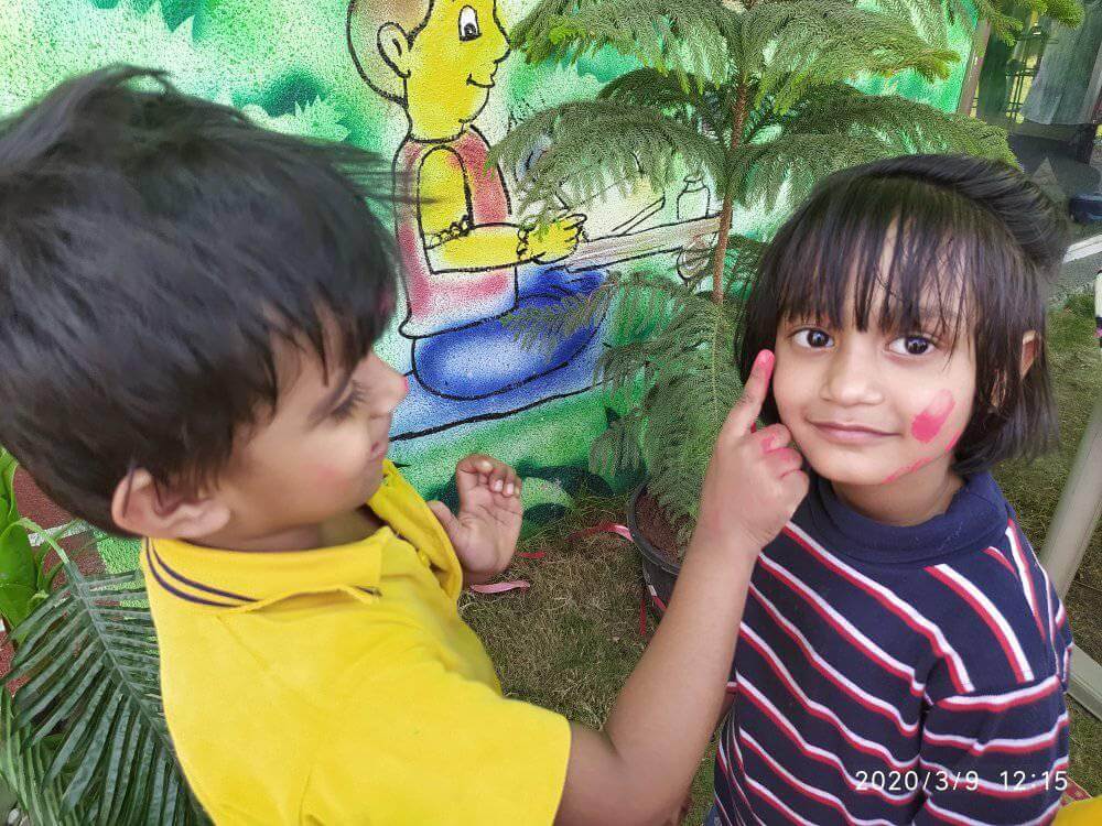 Students and teachers at Dr. Kamna's Gurukool Preschool celebrating Holi with vibrant colors and traditional activities.